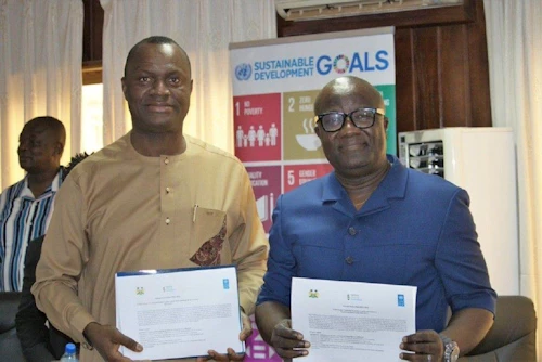 Pa Lamin Beyai fulltrúi UNDP og Mohamed Kenewui Konneh formaður yfirkjörstjórnar Síerra Leoné með samning um verkefnið. Ljósmynd: UNDP